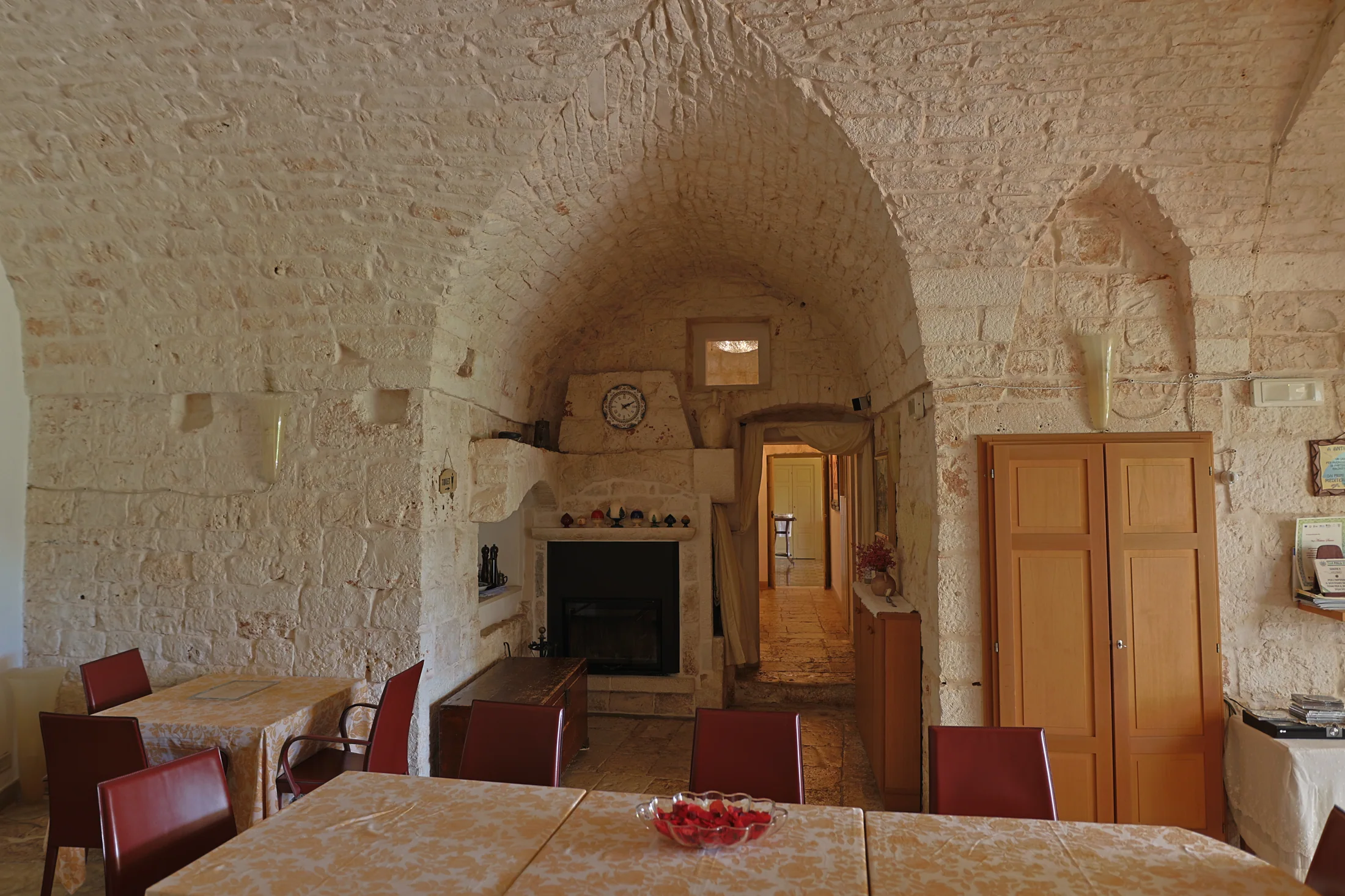 La sala in pietra con il camino e i tavoli apparecchiati